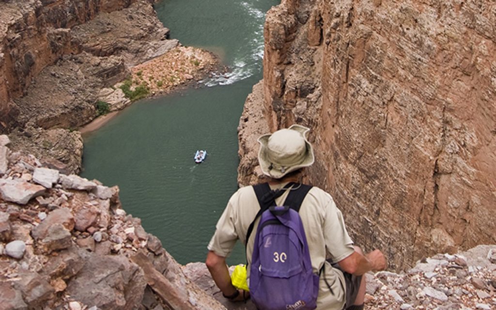 Man looking down at motor raft on the Colorado River