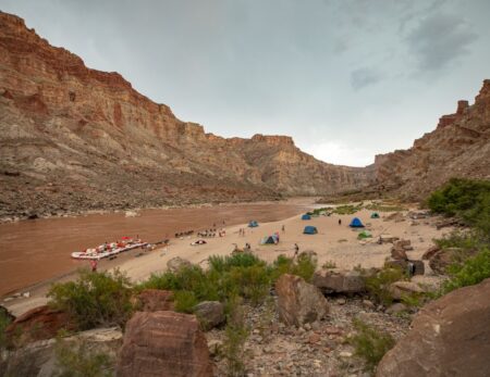 rafters camping on sandy beach next to the Colorado River