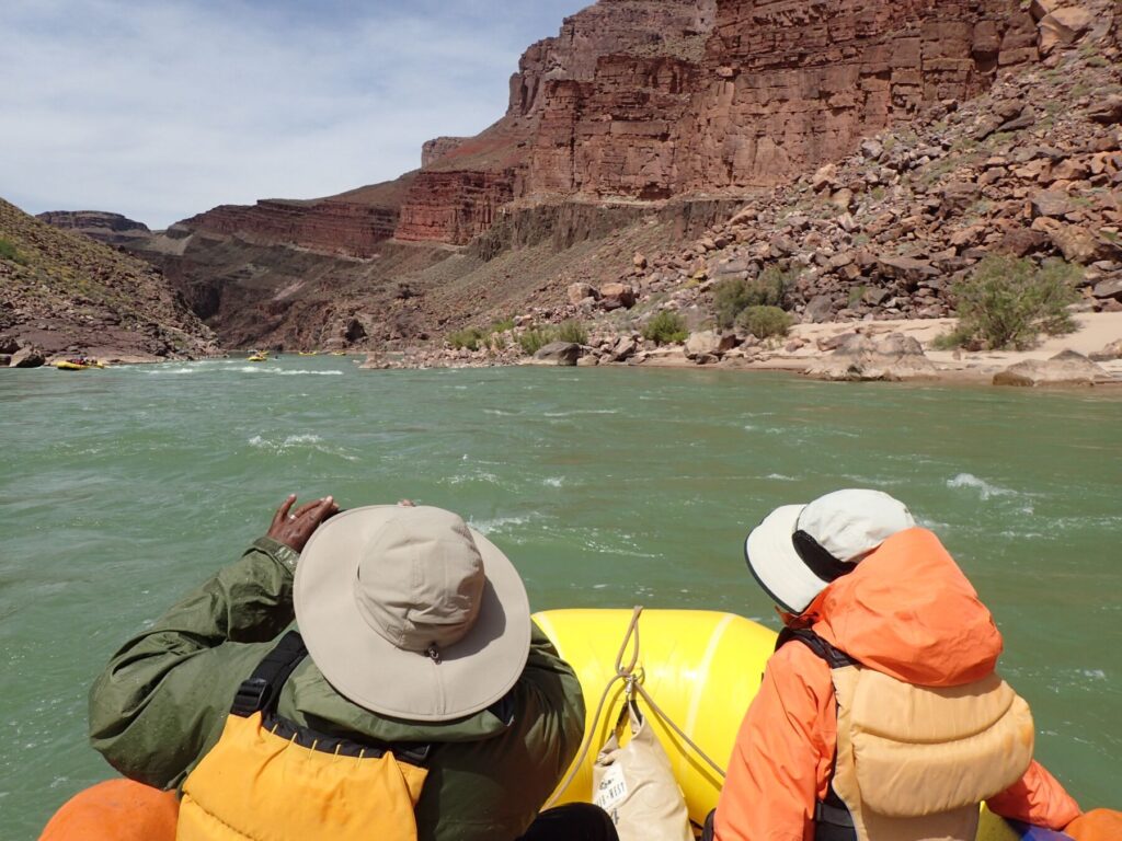 Couple sitting in front of raft on the Colorado river